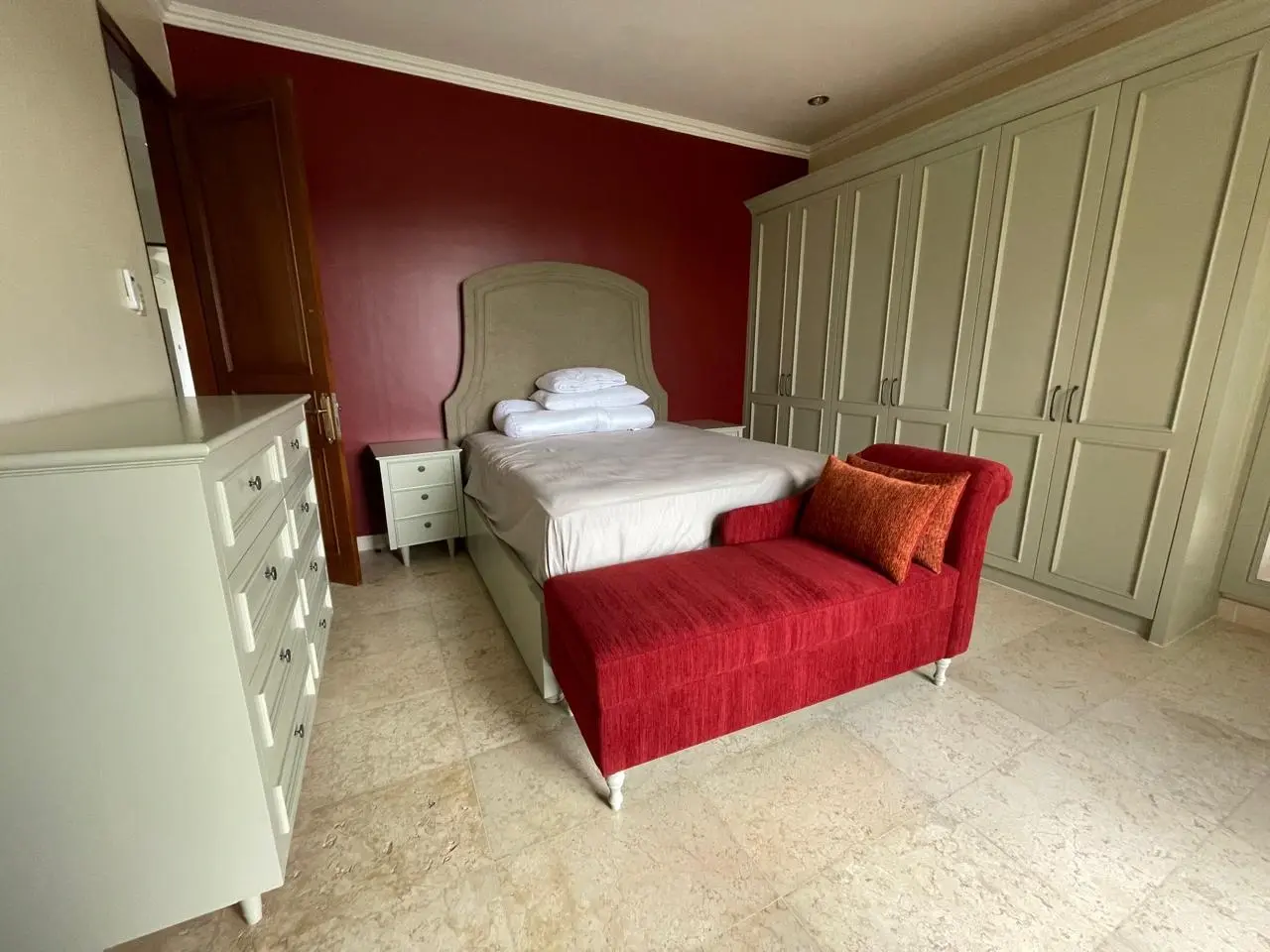 Meja rias klasik dengan cermin tiga panel dan kursi krem di kamar tidur Andara