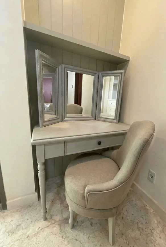 Tampilan keseluruhan kamar tidur klasik dengan dinding maroon, bench merah, dan lemari built-in di Andara