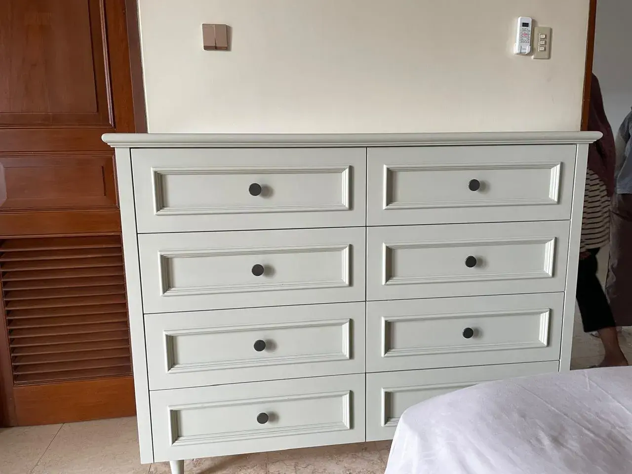 Lemari built-in klasik berwarna sage green dengan panel pintu bertingkat di kamar tidur Andara